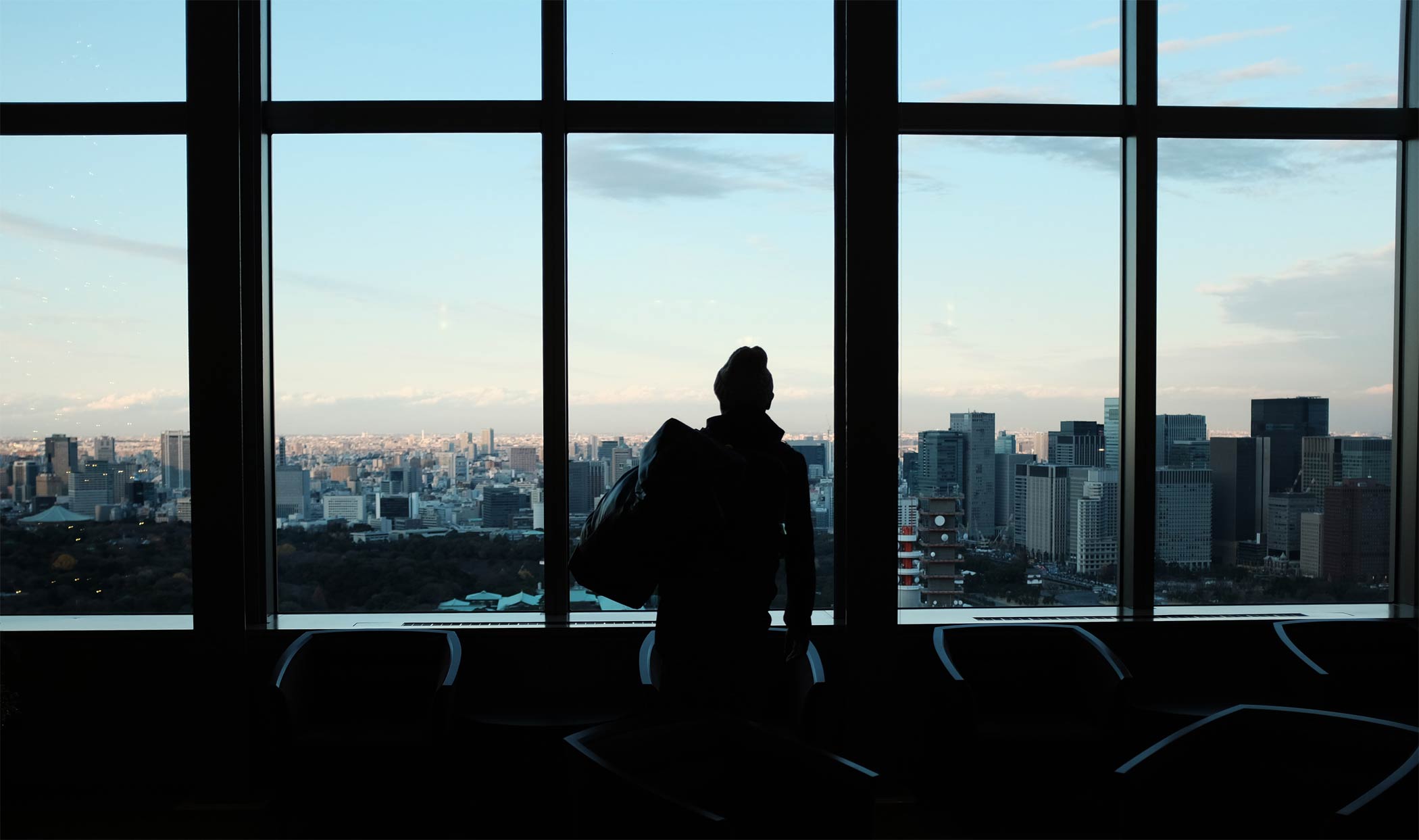 A woman in a high rise business building looking out of the large window to Washington