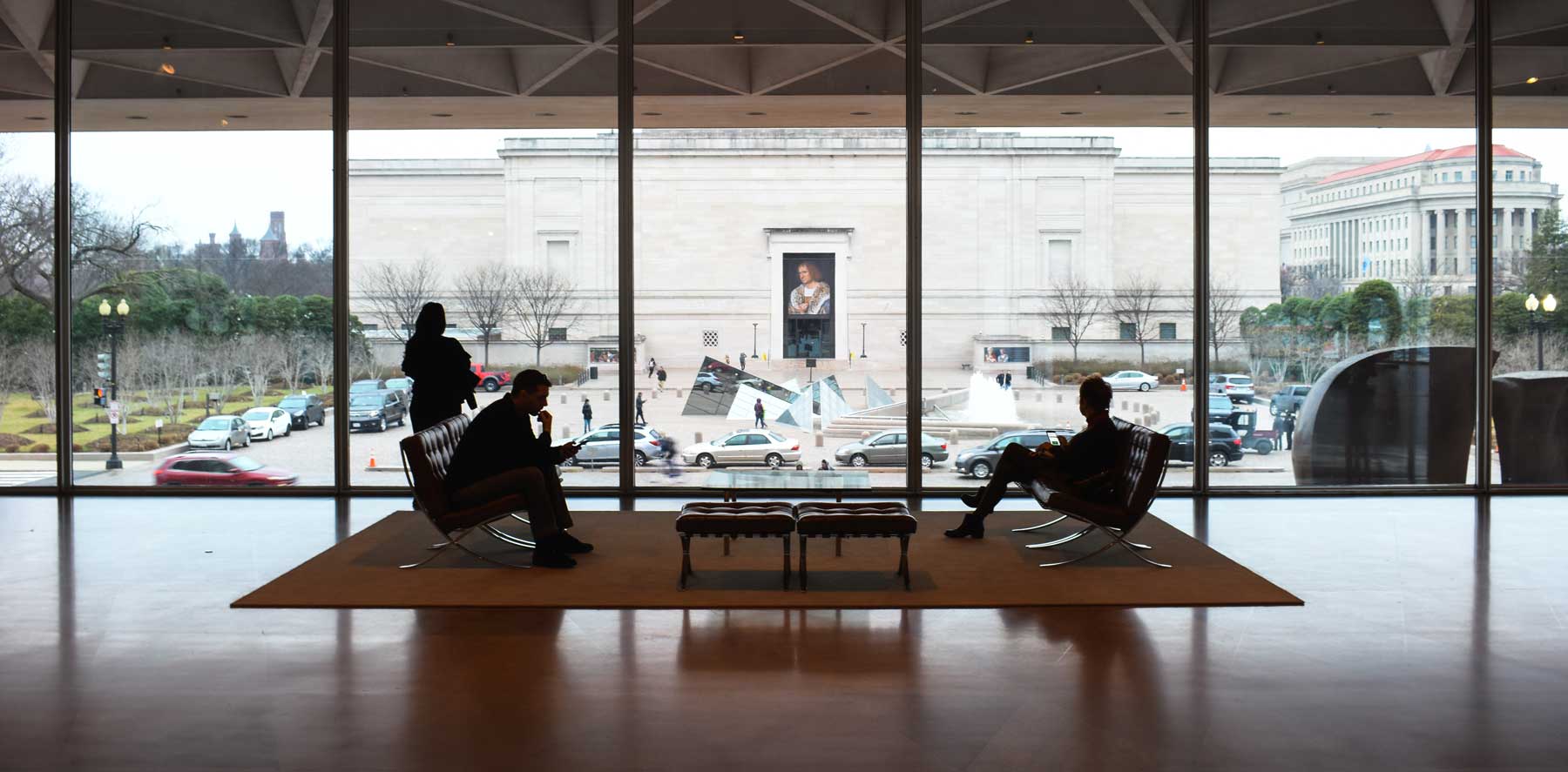 Two business men sitting in a grand lobby over looking Washington DC