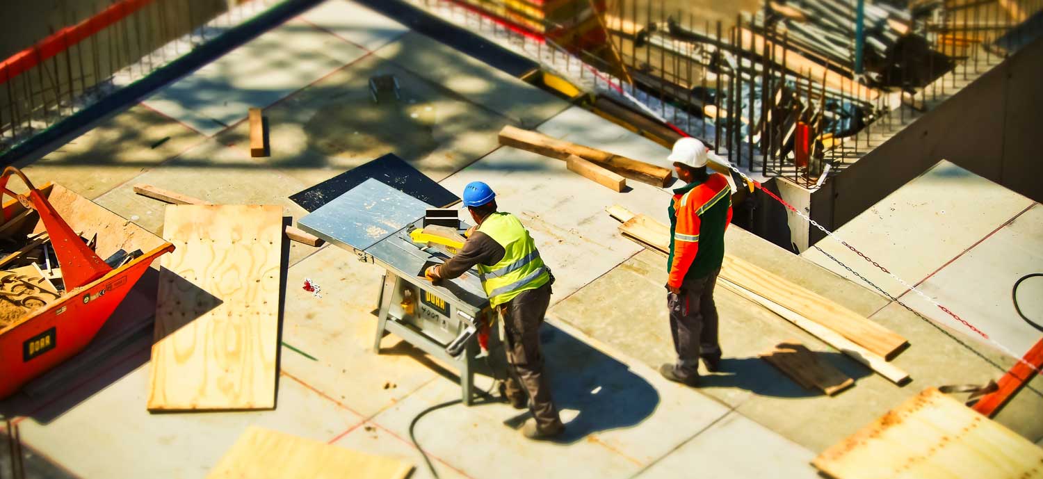 Two construction workers working outside in hard hats