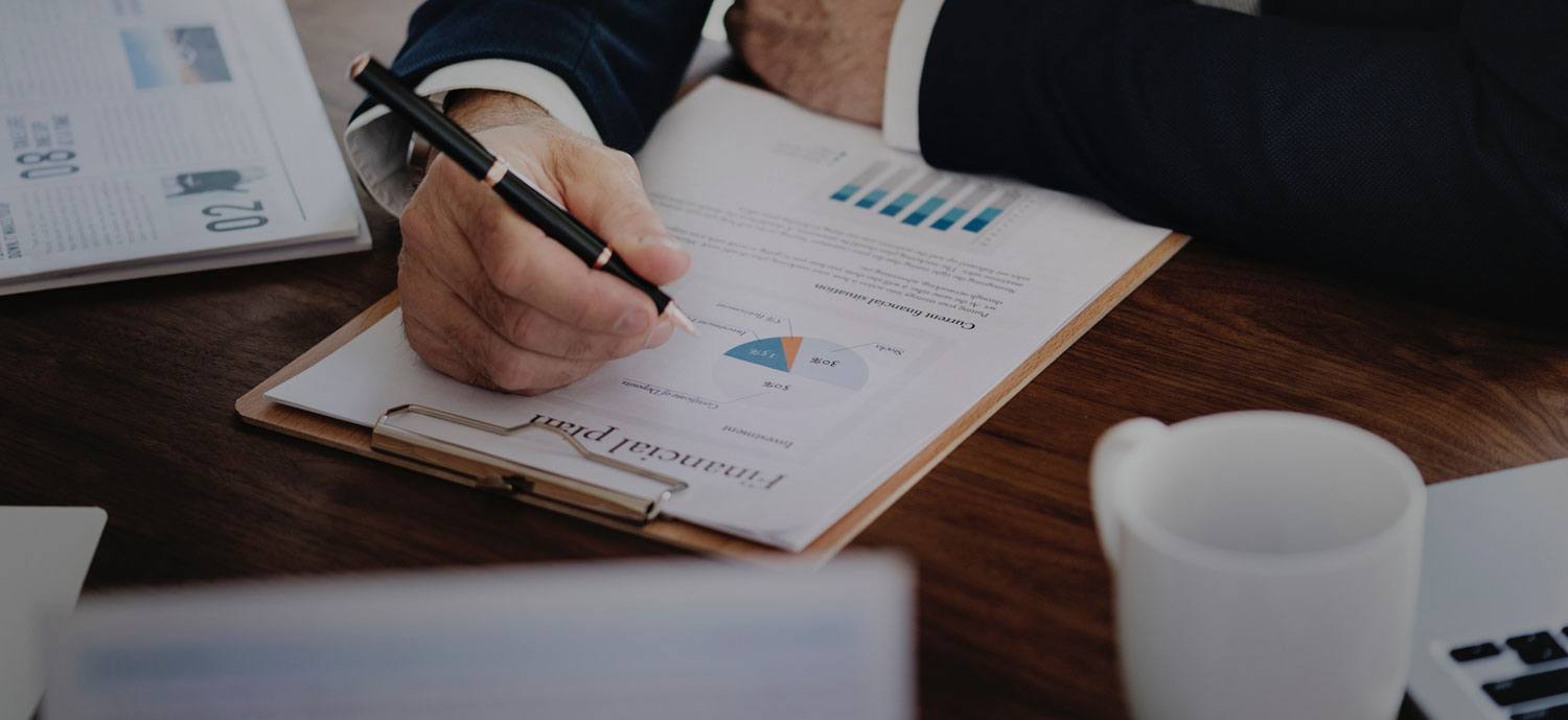 business man working through financial plan documents on a clipboard