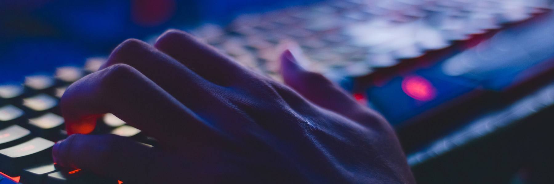 hand working on computer keyboard being dark and mysterious